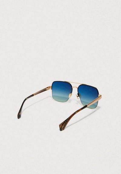 Os óculos de sol quadrados possuem lentes azul em gradiente, armações de metal dourado e hastes com padrão de tartaruga, destacando um design moderno.