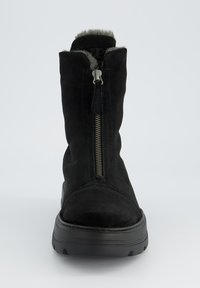 Botte de cheville en suède noir avec une fermeture éclair sur le côté, doublure intérieure en peluche et semelle en caoutchouc noir épais, dotée d'un bout rond et d'un minimalisme dans les détails.