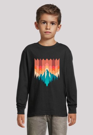 Schwarz langärmliges T-Shirt mit einem Design von Bergen und Wäldern in Türkis, Orange und Pink, mit geometrischen Mustern oberhalb der Illustration.