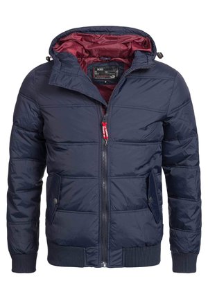 Chaqueta acolchada azul marino con una cremallera roja, capucha desmontable y forro burdeos. Presenta bolsillos laterales y puños acanalados.