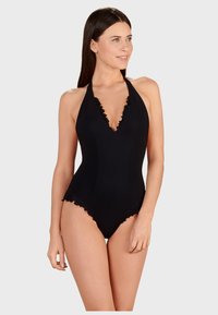 Svart baddräkt med djup halsringning och halterneckband, med vågformade kanter längs halsringningen och benöppningarna. Slät tygtextur.