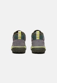 Scarpe da hiking Timberland con tomaia in suede grigia e rete verde, dotate di un accento giallo riflettente e suole in gomma testurizzata per la trazione.