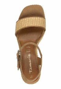 Sandalo con tacco a zeppa in suede marrone caratterizzato da una fascia intrecciata, fibbia regolabile, plantare testurizzato e una soletta liscia con dettaglio del logo.