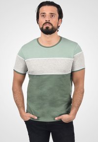 Grøn- og gråstribet t-shirt med korte ærmer. Lavet af bomuldsstof, med rund halsudskæring og kontrastdetaljer ved ærmerne og bunden.