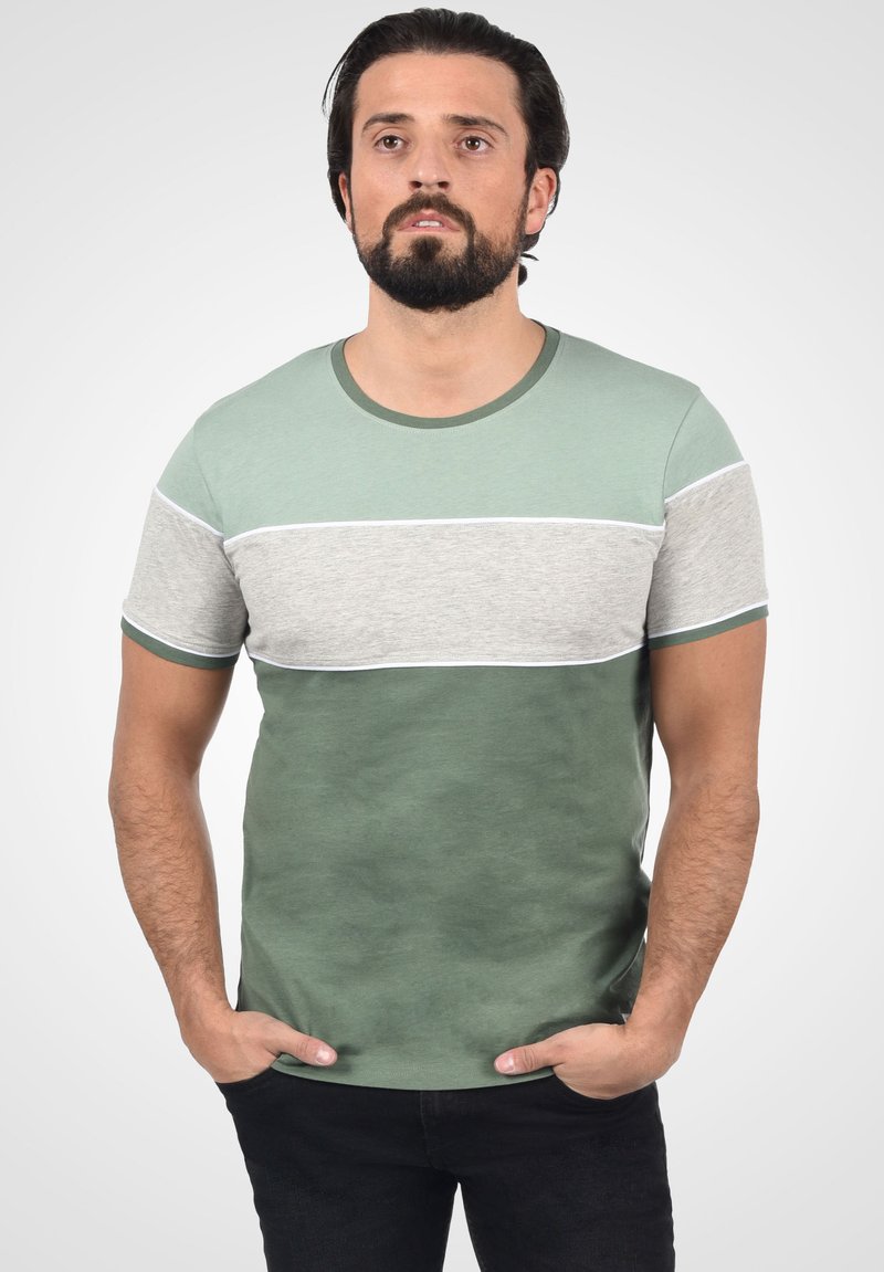 Grøn- og gråstribet t-shirt med korte ærmer. Lavet af bomuldsstof, med rund halsudskæring og kontrastdetaljer ved ærmerne og bunden.