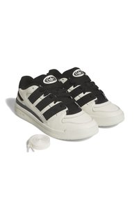 Sneakers in bianco e nero con tomaia in pelle liscia, tre strisce nere, dettagli con logo rotondo e mesh testurizzato sulla linguetta. Lacci extra inclusi.