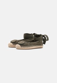 Espadrilles vert olive avec un bout arrondi, une semelle en jute tressé et des lacets en tissu à la cheville. Présente un accent de logo circulaire sur le dessus.