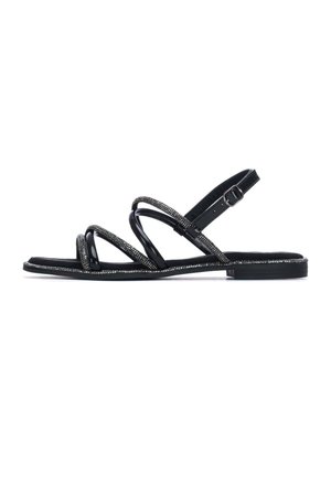 Sandalias de charol negro con correas de múltiples tiras. Presentan una banda texturizada y adornada con detalle de hebilla. Suela plana, diseño minimalista.