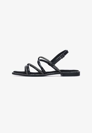 Sandalias de charol negro con correas de múltiples tiras. Presentan una banda texturizada y adornada con detalle de hebilla. Suela plana, diseño minimalista.