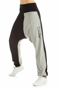 Harem stil hlače v sivo-črni barvni blok obliki, z visokim pasom, ohlapnim krojem in izvezenim logotipom na levi nogi.