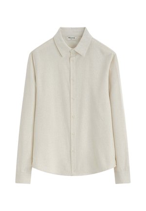 Chemise beige à manches longues et boutonnée, avec un col pointu, présentée à plat sur fond blanc. Aucun motif ni décoration visible.