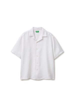 Chemise blanche à manches courtes boutonnée avec col camp et étiquette verte sur fond blanc uni.