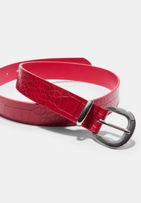 Cintura in pelle rossa con motivo in pelle di coccodrillo, caratterizzata da una fibbia in metallo nero lucido e retro liscio. Estremità arrotondate e fori per la regolazione.