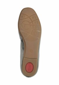 Graue Schuhsohle mit Gummisohle. Strukturierter Profil mit kreisförmigen und wellenartigen Mustern. Enthält einen roten Akzentknopf mit der Aufschrift "KOMFORT."