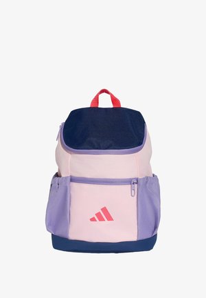 Sac à dos avec rabat supérieur bleu marine, devant rose, poches latérales violettes, poignée rouge et logo rose sur la poche avant sur fond blanc.