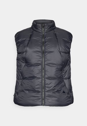 Sötét tengerészkék pufi mellény, könnyű anyagból, magas nyakkal, első zipzárral és oldalzsebekkel. Varrt textúrával és a márka logójával az alsó oldalon.