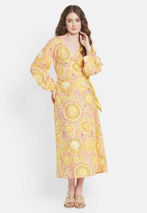 Gelbes Wickelkleid mit langen Ärmeln, das ein Sonnenmuster in rosa und goldenen Tönen zeigt. Der Stoff ist glatt und hat ein fließendes Design.