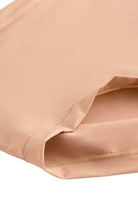 Persikofärgad tyg med en slät textur, med stickade kanter och en lätt urklippt nederkant som indikerar en mjuk, elastisk design.