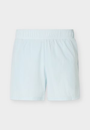 Svetlomodri elastični hlačniki z ravnim krojem, brez vidnih žepov ali vzorcev na enobarvnem ozadju.