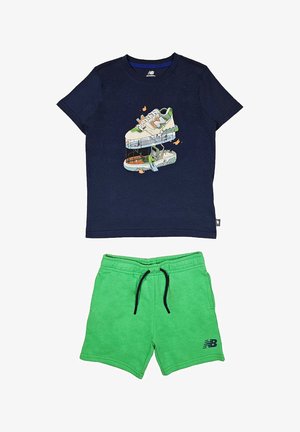 Camiseta de algodón azul marino con gráfico de zapatillas; pantalones cortos verdes con cordón negro y bolsillos laterales, con el logo de New Balance en negro.