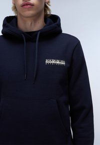 Navy blauwe hoodie gemaakt van een katoenen mengsel, met een voorvak, verstelbare koorden en een geprinte logo op de borst.