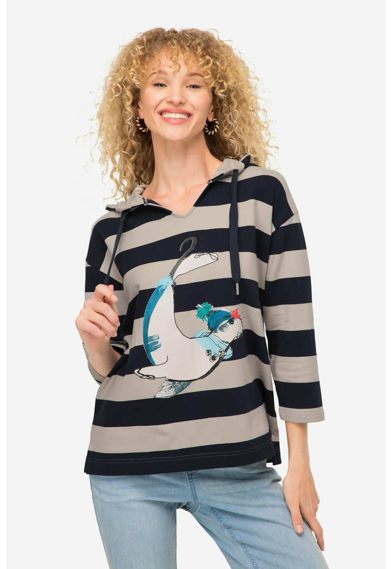 Felpa a righe in blu navy e grigio con coulisse. Presenta una grafica fantasiosa di un pinguino che indossa un cappello blu e pompon rossi.