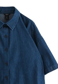 Kortærmet, mørkeblå denimskjorte med klassisk krave, knaplukning og afslappet pasform. Glat tekstur og subtile syninger.