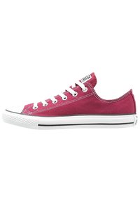 Nízké tenisky z bordó plátna s bílými tkaničkami, gumovou podrážkou a černým pruhem. Mají klasický design a texturovaný svršek.