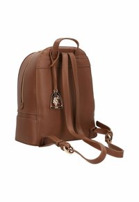 Zaino marrone in pelle con finitura testurizzata, forma arrotondata, manico superiore, cinghie regolabili e un ciondolo metallico decorativo.