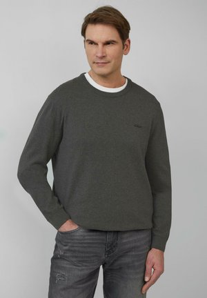 Dunkelgrauer Sweatshirt mit Rundhals und langen Ärmeln. Besitzt ein dezentes Logo auf der Brust. Wird über einem weißen Crew-Neck-Shirt getragen und kombiniert mit grauen Jeans.