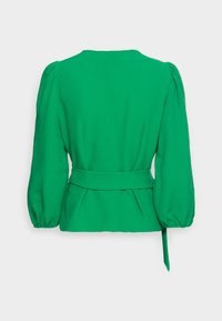 Green blouse with a textured finish, balloon sleeves, a fitted waist, and a tied belt. Features a simple round neckline and pleated back.