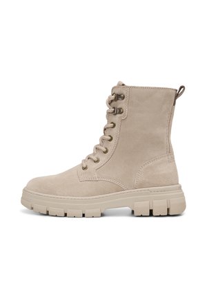 Beige suède veter-enkellaars met dikke rubberen zool, metalen veteroogjes, trekkoord aan de achterkant en gedetailleerd stiksel.