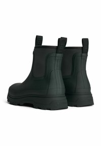 Mustat vedenpitävät nilkkurit, joissa on teksturoitu pinta, vetotaitokset ja kestävät pohjat, jotka tarjoavat pitoa. Vankka, joustava kumimateriaali.