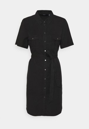 Robe boutonnée noire à manches courtes, avec deux poches poitrine et une ceinture à nouer. Confectionnée dans un tissu lisse avec une coupe légèrement cintrée.