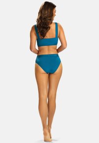 Turkusowy dwuczęściowy strój kąpielowy składający się z topu z szerokimi ramiączkami oraz wysokich majtek bikini. Gładka faktura, minimalne zdobienia.