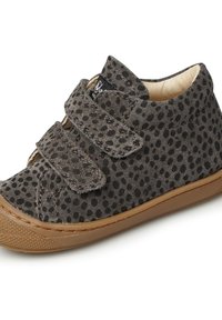 Zapato de ante gris con puntos negros, doble correa de Velcro, puntera redondeada y suela de goma marrón. Forro interior suave para mayor comodidad.