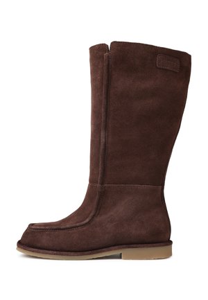 Bottes en suède marron jusqu'au genou avec une texture lisse, un bout arrondi et une semelle plate. Présentent un détail de couture sur le côté et un patch logo discret.