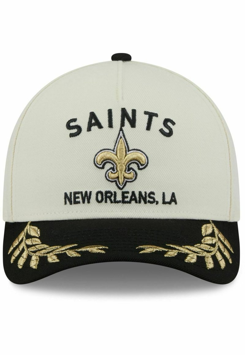 White cap with black brim, embroidered "SAINTS" and fleur-de-lis in gold, and decorative gold leaf accents on the brim.