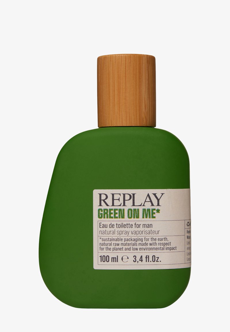 Grön rektangulär flaska med rundad form och bambuskruvkork. Etiketten visar "REPLAY GREEN ON ME" med produktinformation. Kapacitet 100 ml.