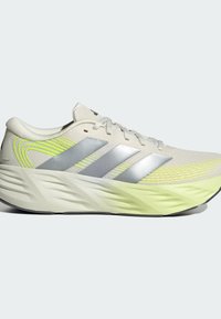 Light beige and neon yellow running shoe with silver stripes, cushioned sole, and lace-up front, shown in side profile.
