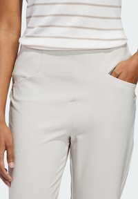 Φωτεινό μπεζ παντελόνι με ομαλή υφή, διαθέτει δύο πλαϊνές τσέπες και εφαρμοστή γραμμή. Το ύφασμα φαίνεται ελαστικό και διαπνέον.