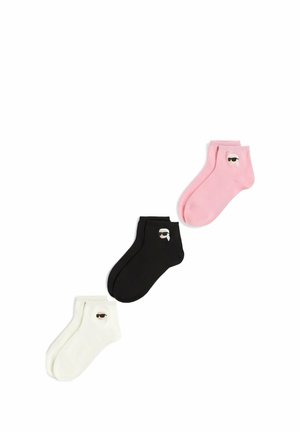 Trois paires de chaussettes chevilles en blanc, noir et rose, chacune avec un petit dessin d’une personne portant des lunettes de soleil et une queue de cheval blanche.