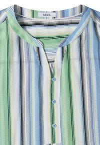 Blouse sans col avec des rayures verticales vertes, bleues, blanches, noires et jaunes, dotée d’une patte de boutonnage partielle avec trois boutons bleus.