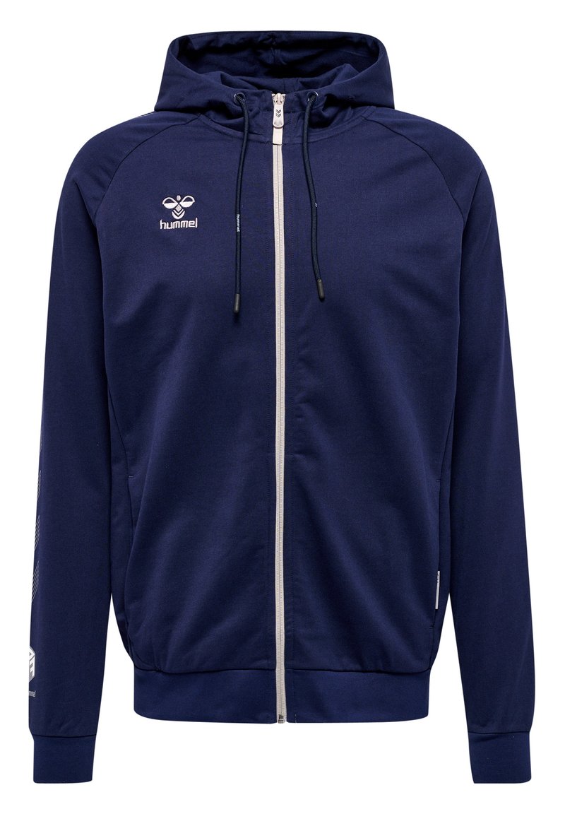 Marineblauwe hoodie met ritssluiting aan de voorkant, trekkoorden en witte accenten. Bevat een logo op de borst en diagonale strepen op de mouwen.