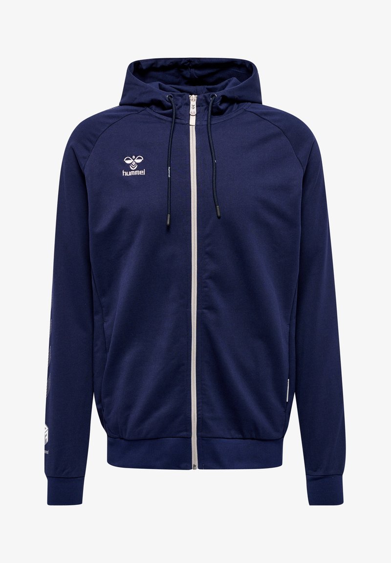 Marineblauwe hoodie met ritssluiting aan de voorkant, trekkoorden en witte accenten. Bevat een logo op de borst en diagonale strepen op de mouwen.