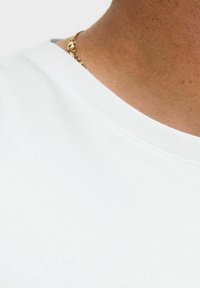 Hvid bomulds-T-shirt med rund halsudskæring, der har en glat textur og et close-up billede af skulderområdet og halsen, der viser hud og en guld kæde.