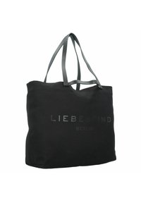 Svart tygväska i bomull med en mjuk yta. Har långa, platta grå handtag och en präglad logotyp med texten "LIEBESKIND BERLIN."