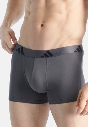 Calzoncillos boxer gris para hombres con una cinturilla que presenta acentos de logo en negro. Fabricados con un material suave y elástico para mayor comodidad y ajuste.