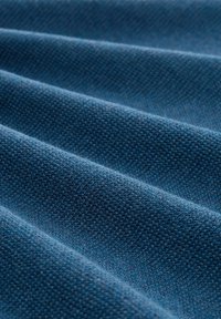 Tejido azul texturizado con una trama fina y uniforme, que muestra capas suaves y sutiles y un patrón acanalado pronunciado. Ideal para diversas aplicaciones textiles.