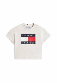Beżowy krótki T-shirt z logo "Tommy Hilfiger" z prostokątnym wzorem w kolorach czerwonym, białym i czarnym z przodu.